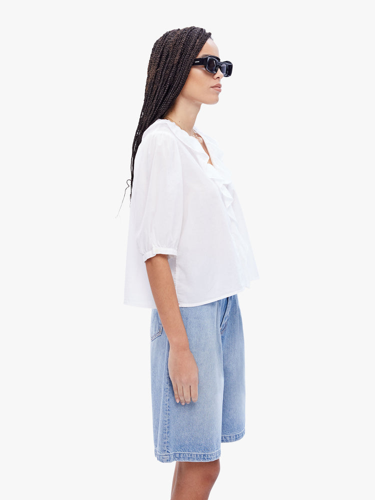 Side view of a woman in a 100% cotton white blouse from XiRENA, this blouse features a ruffled Vneck, 3/4 length balloon sleeves and a loose fit