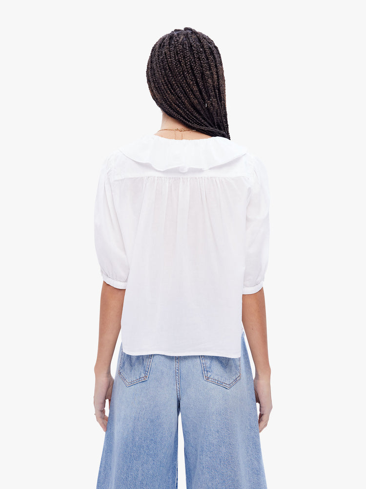 Back view of a woman in a 100% cotton white blouse from XiRENA, this blouse features a ruffled Vneck, 3/4 length balloon sleeves and a loose fit