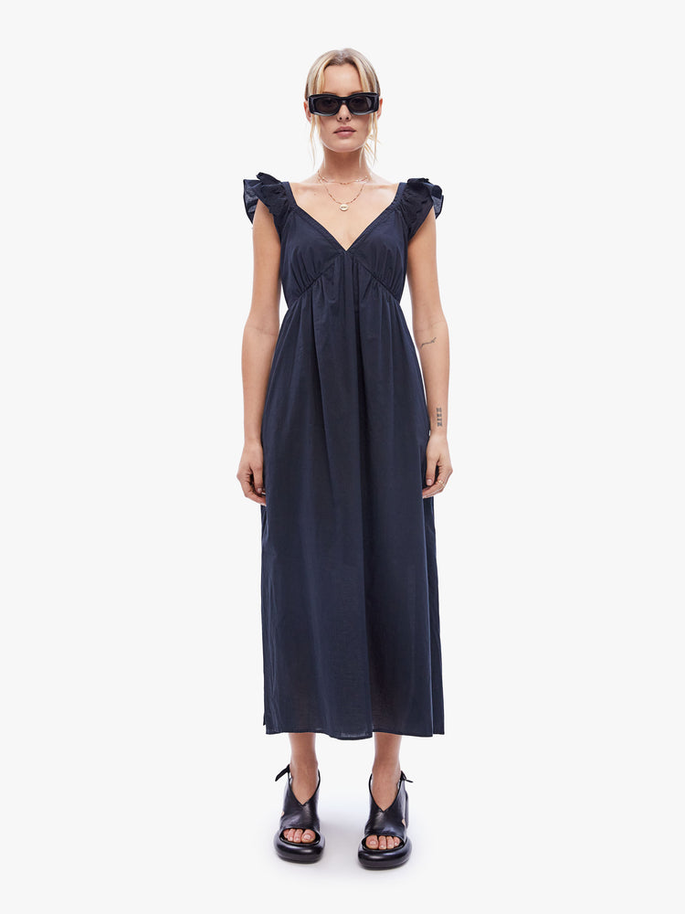 Front full body view of woman in the Leia dress from XiRENA made from 100% cotton in black, the maxi dress is designed with a Vneck, short ruffled sleeves, an empire waist and a loose, flowy fit