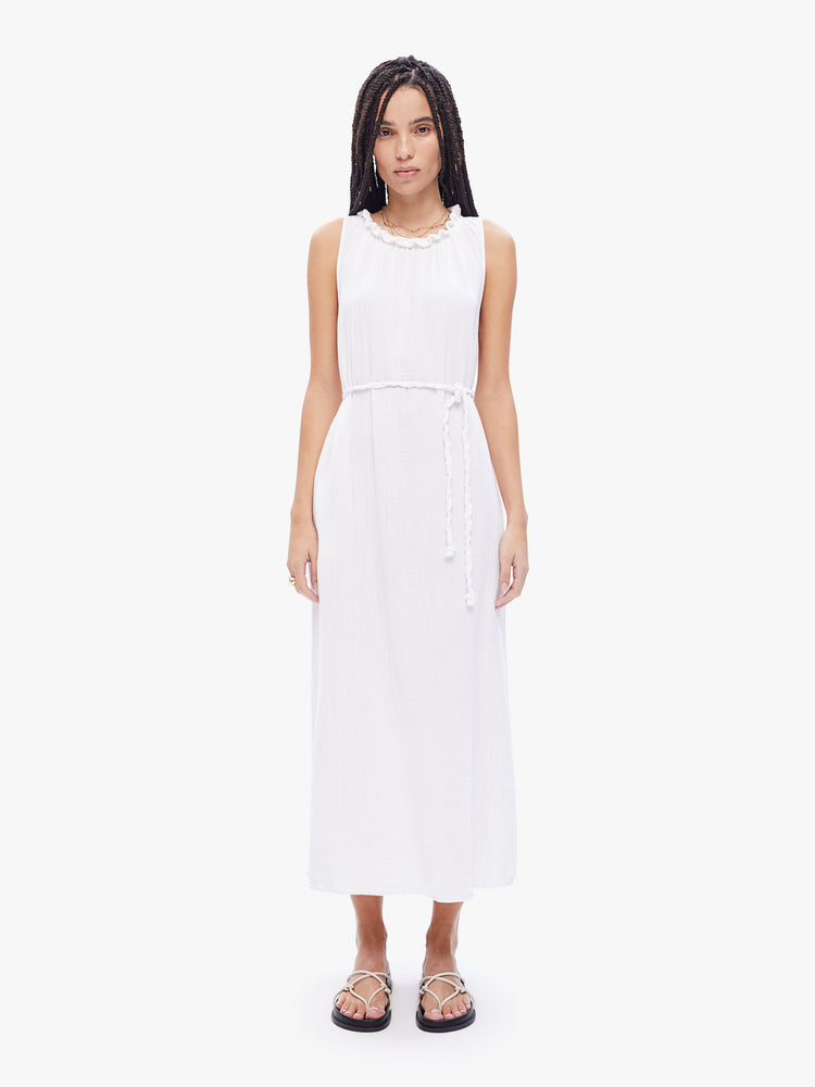 Front full body view of a woman in a sleeveless maxi dress from XiRENA, dress is made from 100% cotton in white and features a ruffled crewneck, tied waist, ankle length hem and effortless vibe