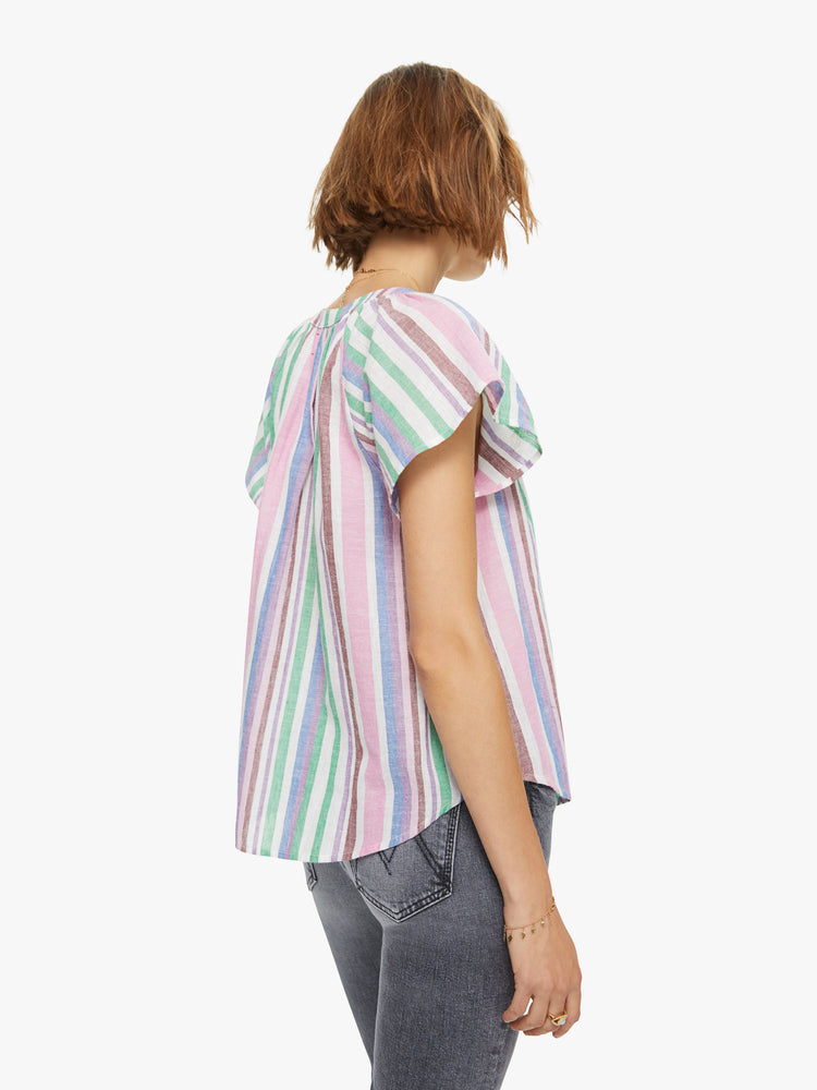 Back view of a woman in a 100% cotton in a baby pink, periwinkle and mint green stripe pattern, the Kimber top is designed with a buttoned V-neck, drop shoulders and a curved hem with side slits.