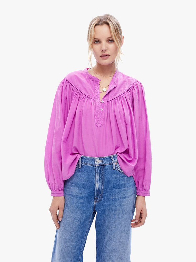 Front view of a woman in a casual blouse by XiRENA made from a blend of cotton and silk in a bright purple hue, the blouse is designed with long balloon sleeves and a buttoned vneck with ruffles throughout for a loose, flowy fit