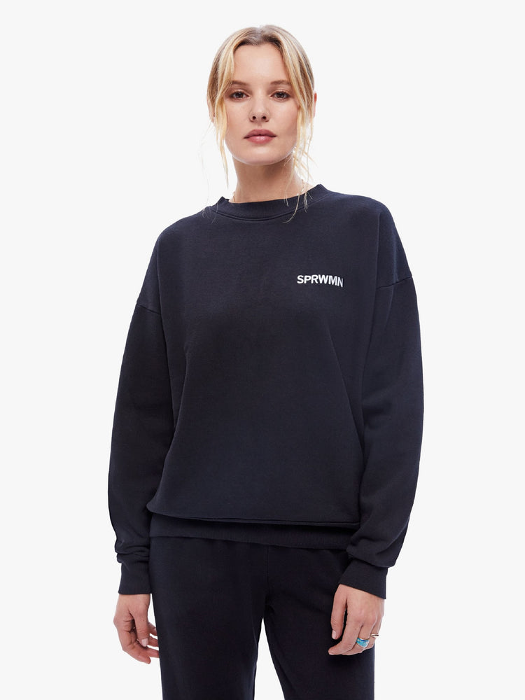 Front view of a womens black sweatshirt featuring a crew neck with dropped sleeves and "SPRWMN" printed on the chest.