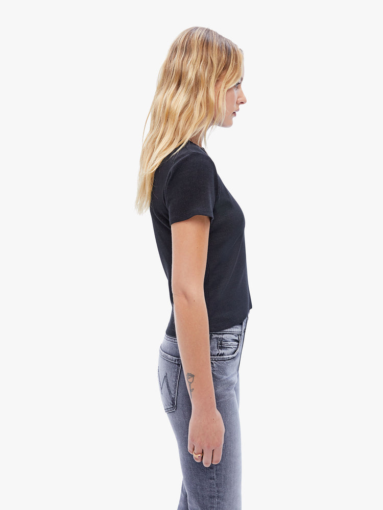 Side view of a woman in a baby tee from the Los Angeles brand SPRWMN made from a soft stretchy fabric in black the super cozy shirt has a hip length hem, short sleeves and a semi fitted shape