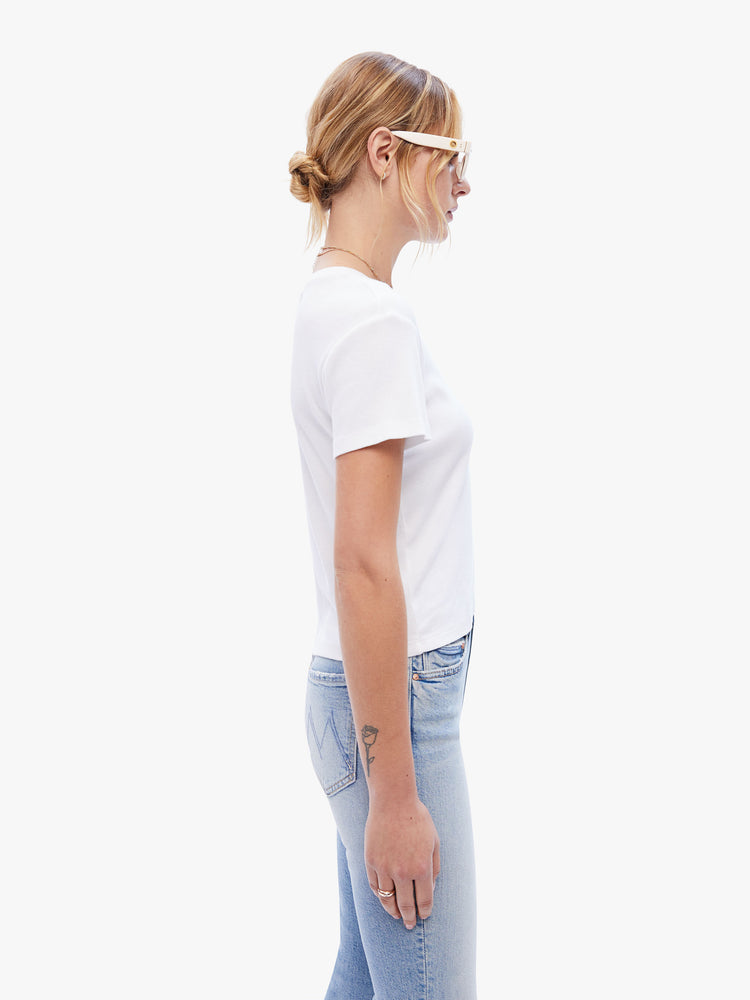 Side view of a woman in a baby tee from the Los Angeles brand SPRWMN made from a soft stretchy fabric in white the super cozy shirt has a hip length hem, short sleeves and a semi fitted shape