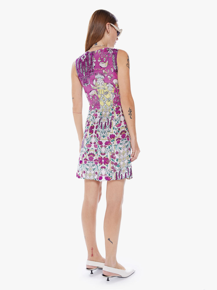 Back full body view a woman in a sleeveless mini dress from Maria Cher, dress in made from 100% silk in a purple, pink and red print and features a V-neck, pleated empire waist and a slim fit