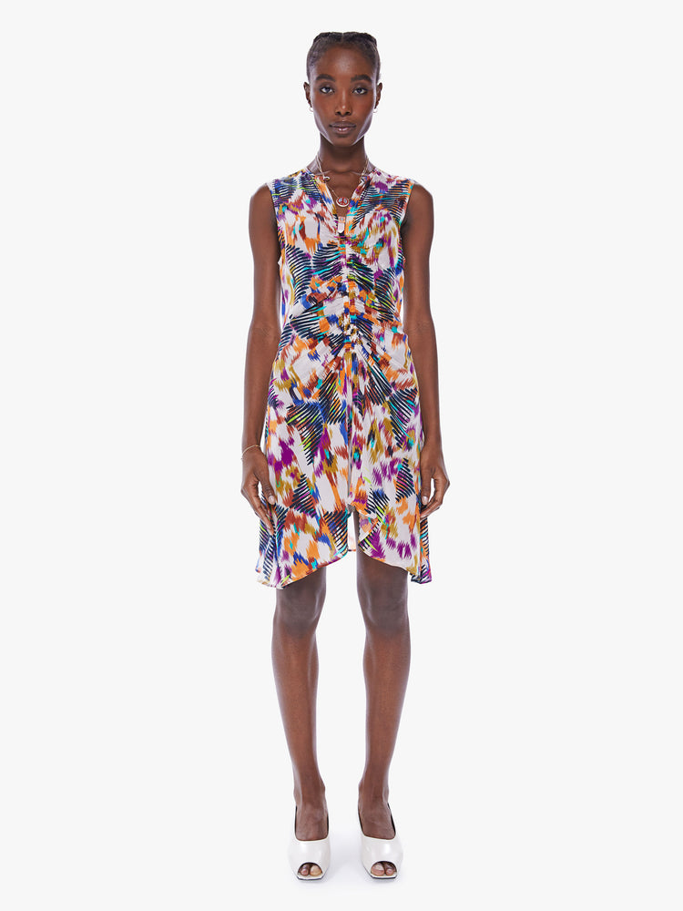 Front full body view of a woman in a sleeveless mini dress from Maria Cher, dress is designed in a blue, purple and orange print and features a V-neck, a pleated empire waist and a slim fit