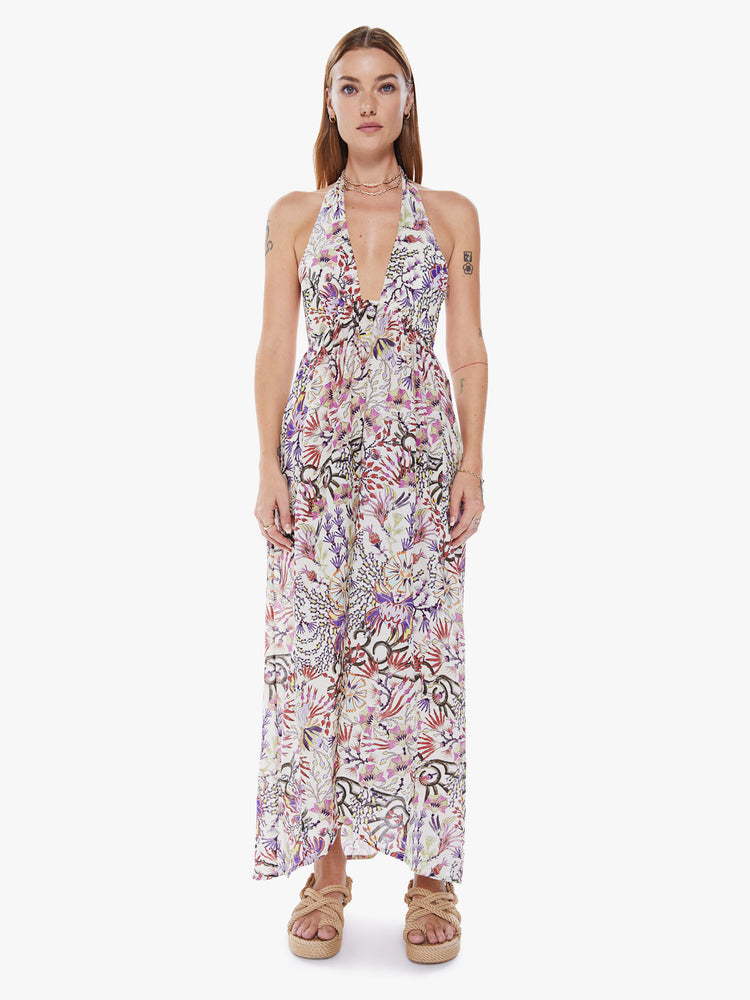 Front view of a woman in a sleeveless Maxi dress from Maria Cher a brand inspired by the founders hometown of Buenos Aires which reinterprets classic styles with bold prints and modern neutrals made from a blend of cotton and silk in a colorful abstract floral print and features a halter top with a deep Vneck, an empire waist and an ankle length skirt with flowy fit