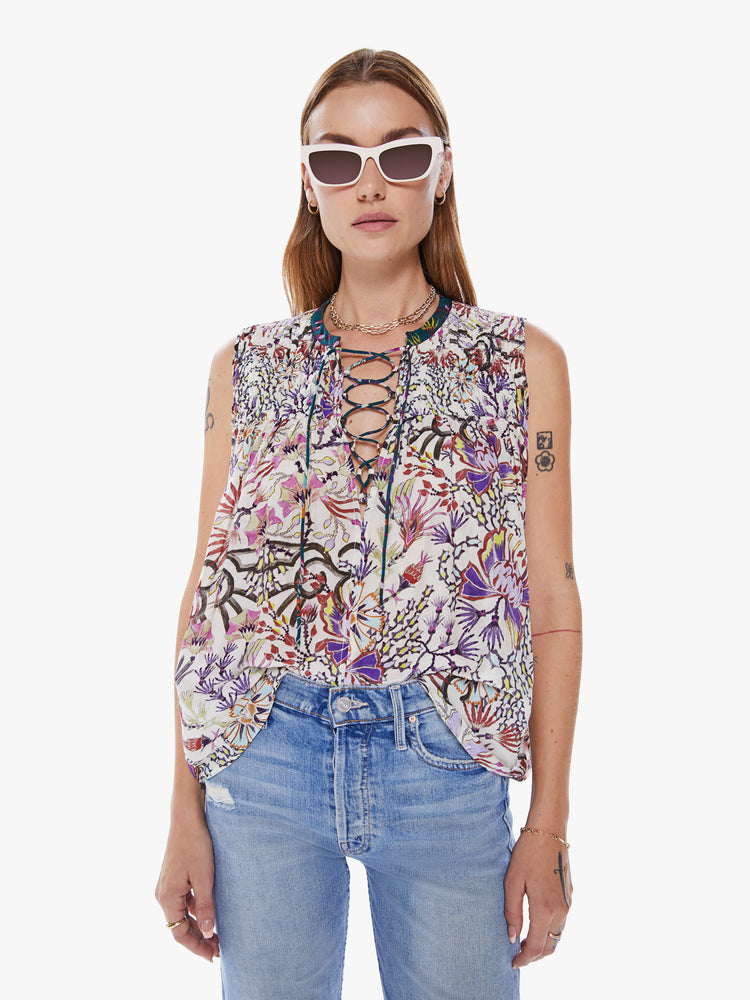 Front view of a woman in a Maria Cher blouse with bold prints and modern neutrals, made from a blend of cotton and silk in a colorful abstract floral print, the sleeveless blouse features a deep Vneck that laces and ties, a hip grazing hem and a loose, flowy fit