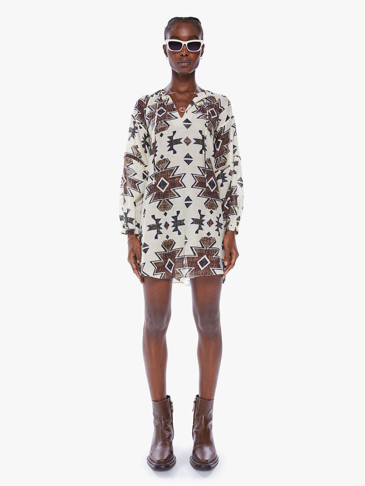 Front view of a woman in long sleeve mini dress from Maria Cher which reinterprets classic styles with bold prints and modern neutrals, the dress is made from a blend of cotton and silk in white with a dark pattern and features a Vneck, long balloon sleeves and a slightly curved hem that hits mid thigh