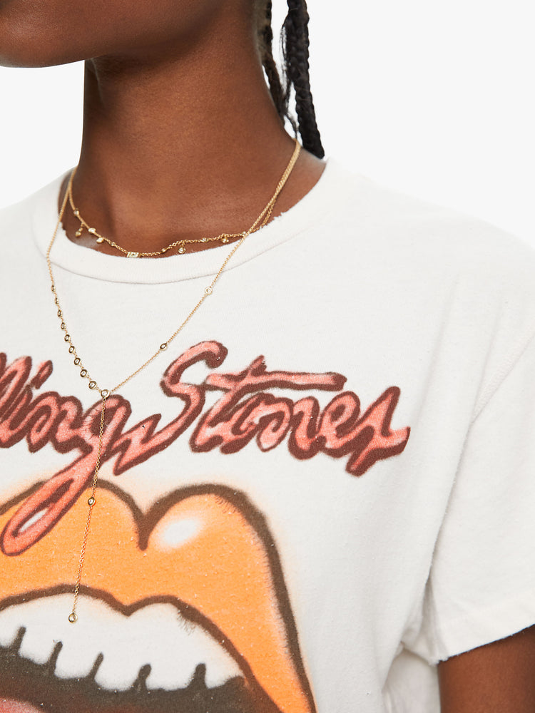 Close up view crewneck tee by MadeWorn with a relaxed fit. Made of 100% cotton in white, the tee pays homage to the Rolling Stones with an airbrushed graphic of the band's iconic tongue-and-lips logo on the front.