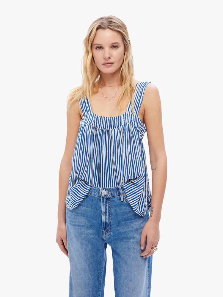 Front view of a womens sleeveless blouse featuring white and blue stripes and a flowy fit.