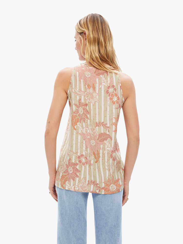 Back view of woman hip-grazing hem and a loose, boxy fit tank in a tan stripe pattern with warm-toned sunflowers.