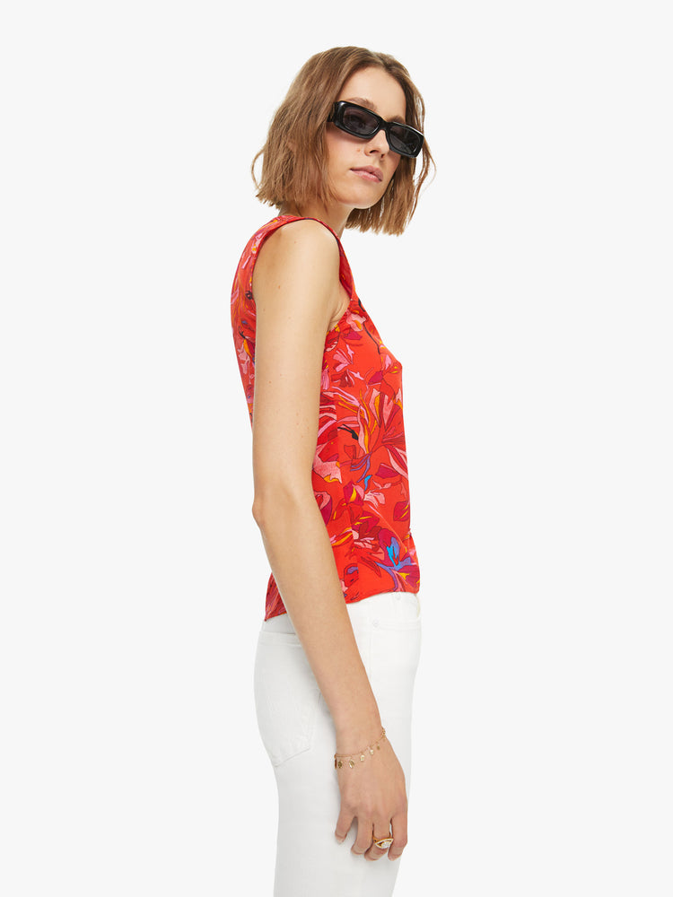 Side view of a woman sleeveless top in a red, blue and yellow abstract print, and features a V-neck, gathered seam down the front and a slim fit.