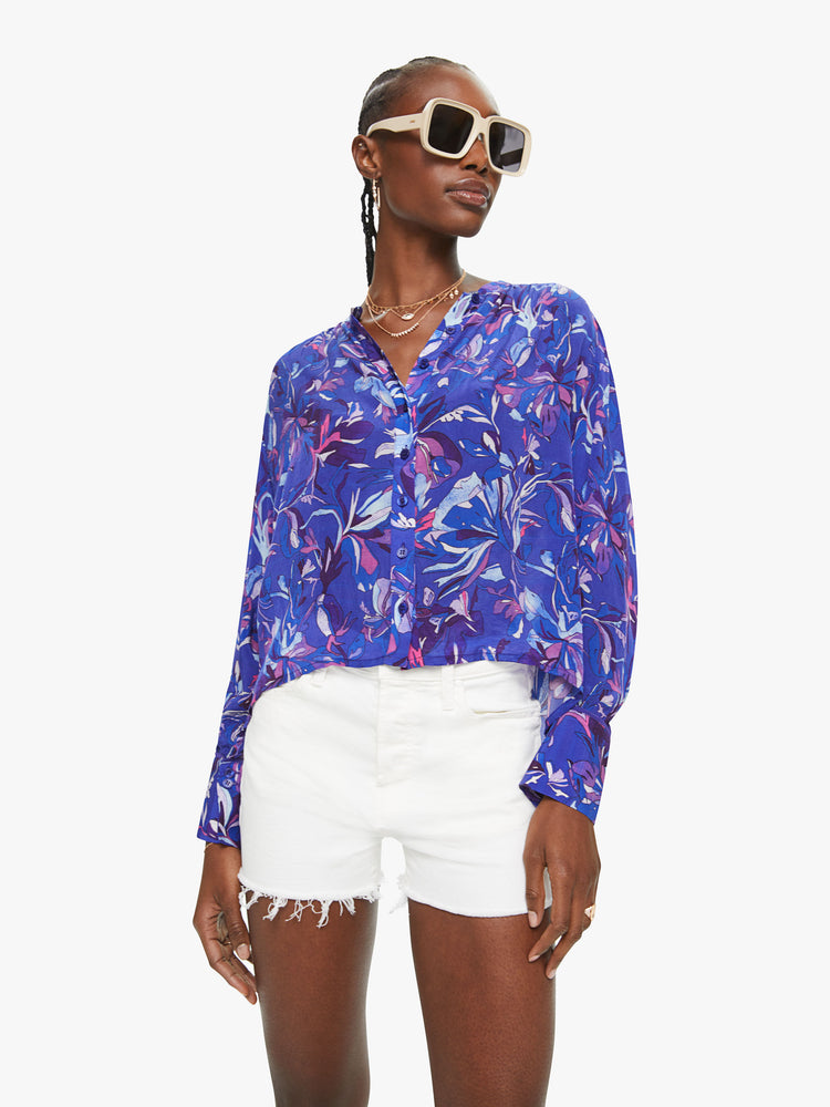 Front view of a woman top with a blue abstract print,  V-neck, long balloon sleeves with extra-wide hems at the wrists and ruffles with loose fit.