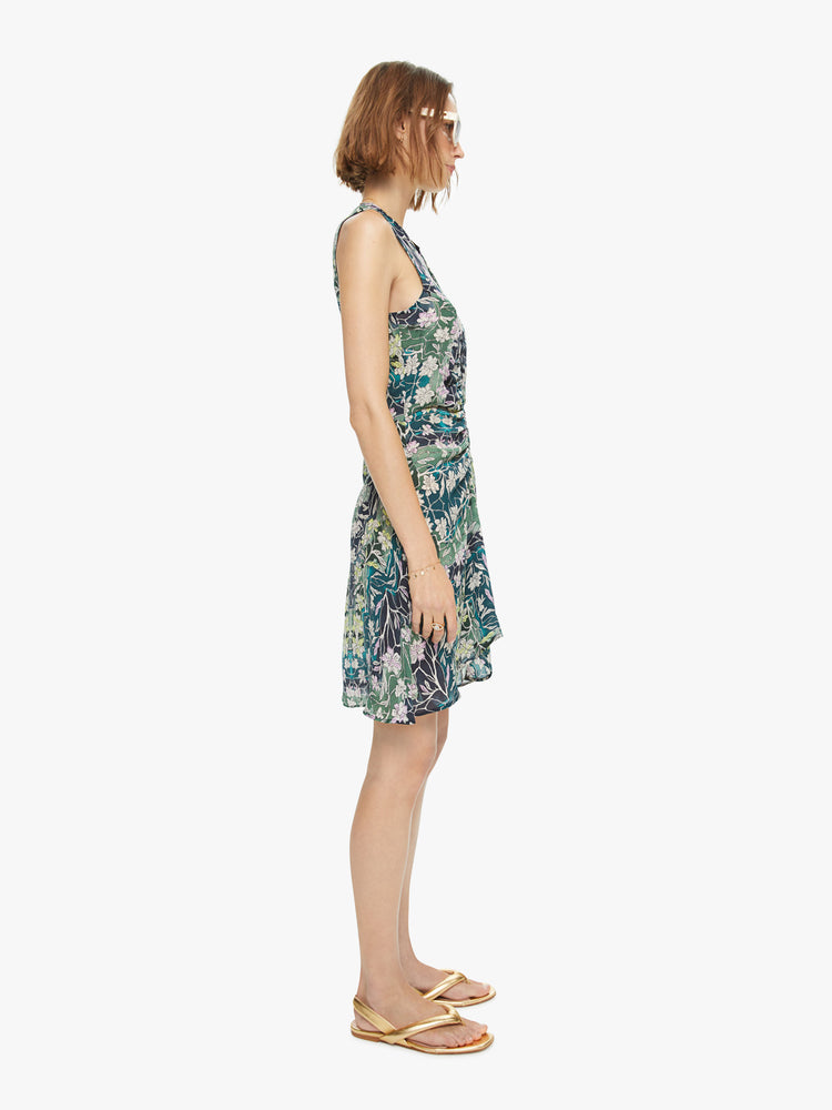 Side view of woman's sleeveless mini dress in a blue, green, and yellow abstract print with a slim fit.