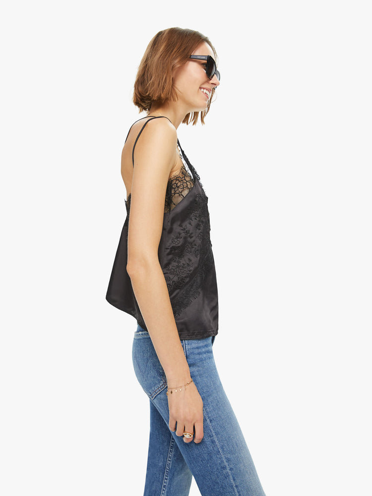 Side view of a woman black lace top with V-neck , buttons down the front and spaghetti straps.