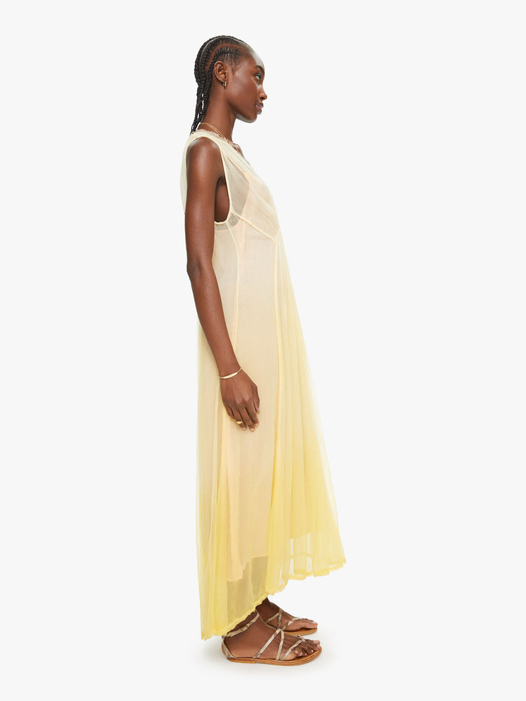 Side view of a woman yellow ombre hue maxi dress with Vneck and uneven hem.