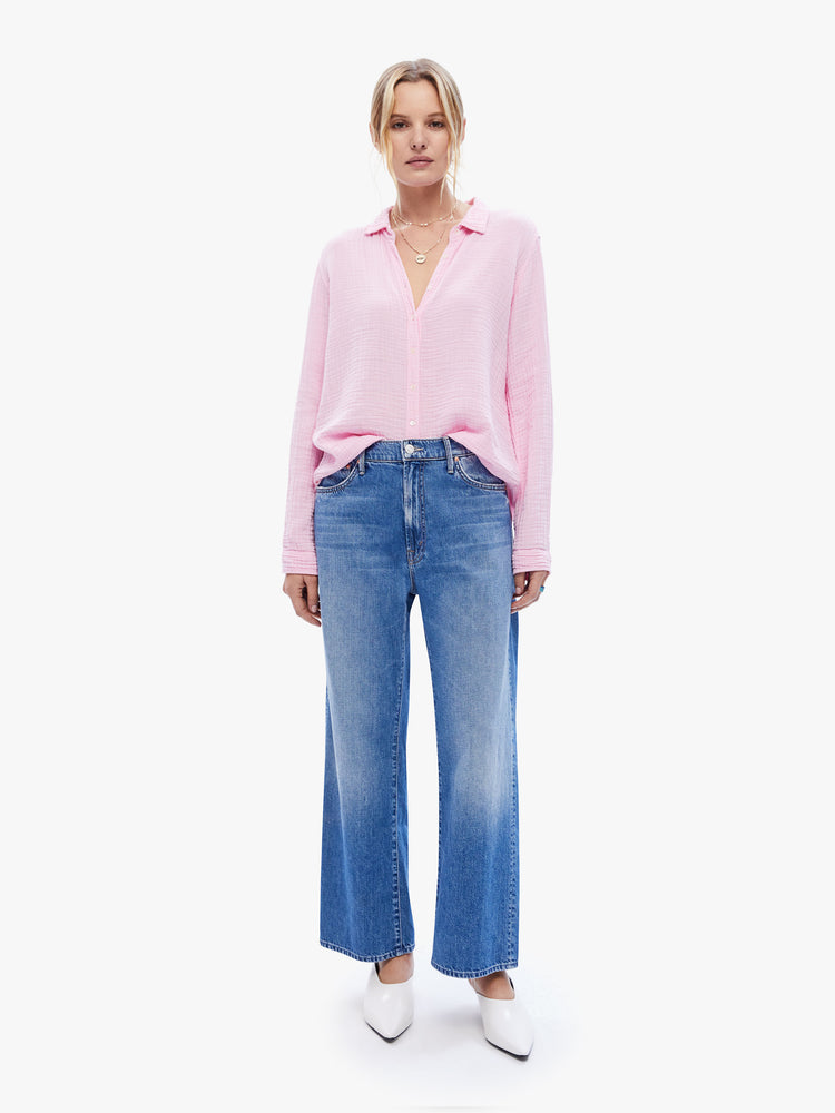 Front full body view of a woman in a baby pink button down from XiRena, the long sleeve shirt features a Vneck and curved hem with a light and airy fit