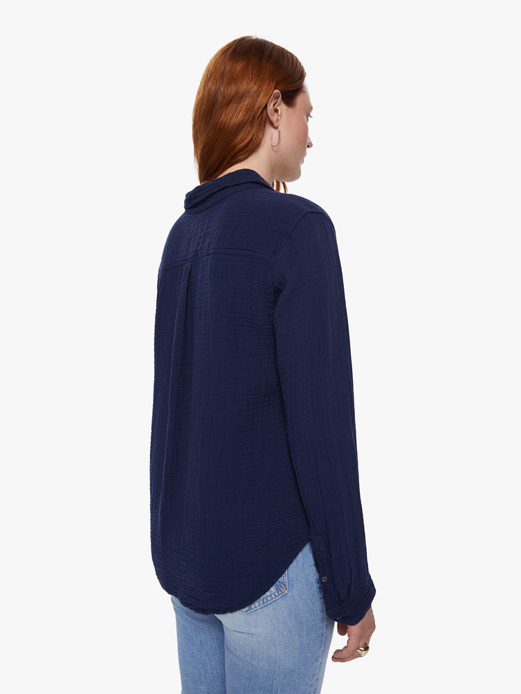 A back view of a woman wearing a navy button up shirt