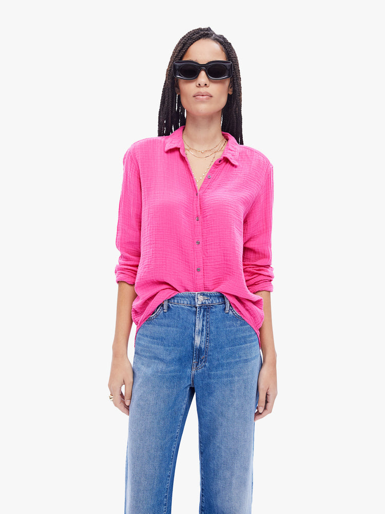 Front view of a woman in hot pink button down from XiRENA made from 100% cotton, the long sleeve shirt features a Vneck and curved hem with a light and airy fit