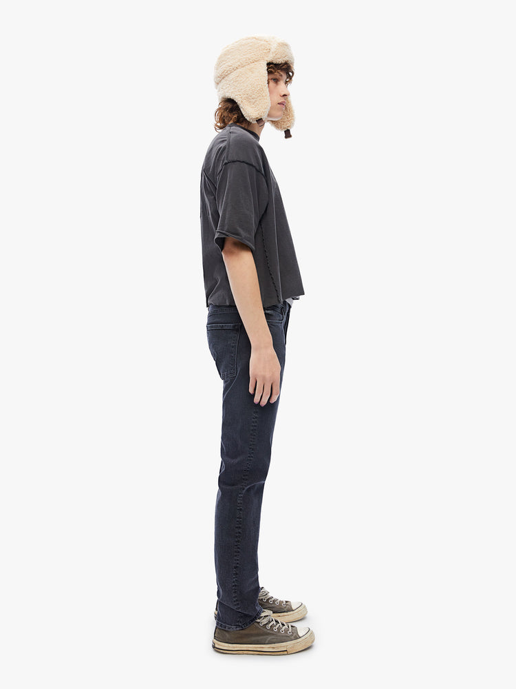 Side view of a mens black jean featuring a straight leg and clean hem.