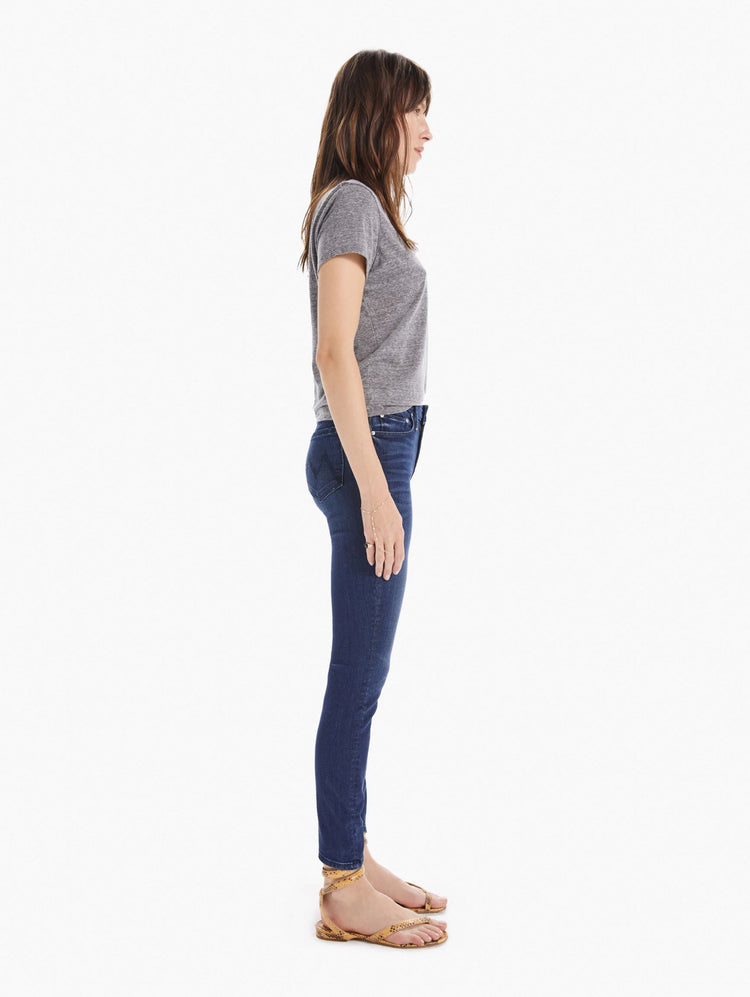 Side view of women's dark blue mid rise skinny with zip fly and clean hem