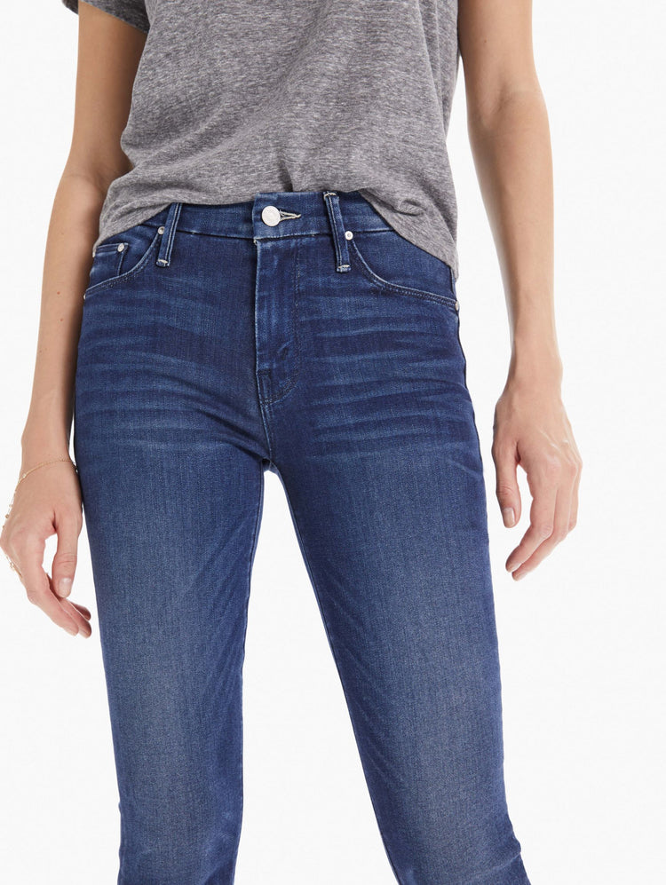 Detail view of women's dark blue mid rise skinny with zip fly and clean hem