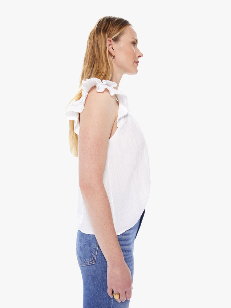 Side view of a women's white tank top with scoop neck and ruffled sleeves