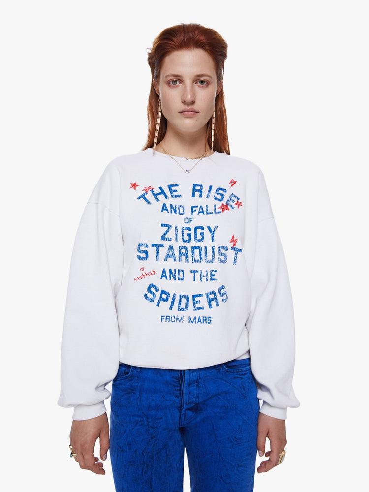 Front view of a woman in a crewneck sweatshirt from Mothers David Bowie capsule collection the 100% cotton sweatshirts is designed with dropped sleeves and a relaxed fit and features a blue and red text graphic on the front