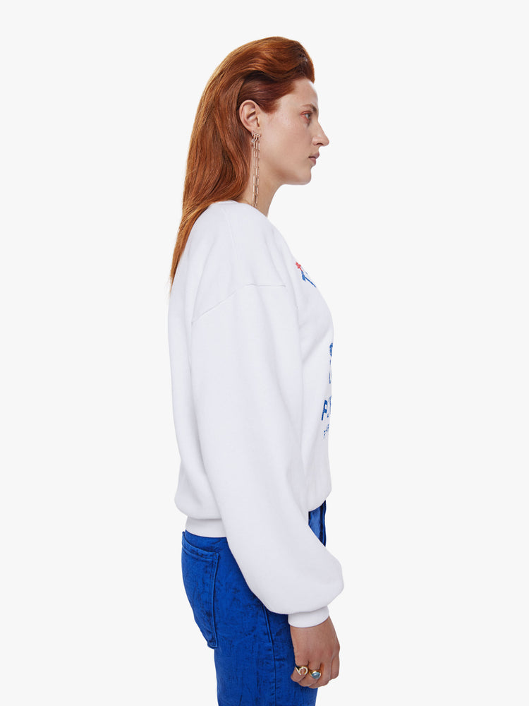 Side view of a woman in a crewneck sweatshirt from Mothers David Bowie capsule collection the 100% cotton sweatshirts is designed with dropped sleeves and a relaxed fit and features a blue and red text graphic on the front