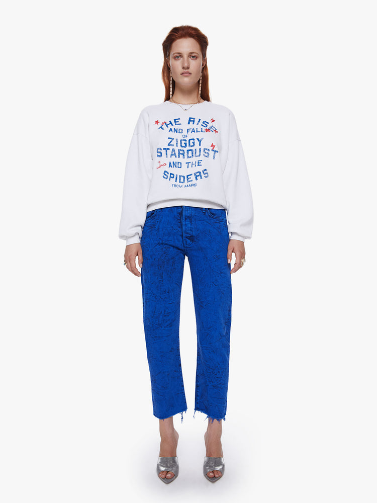 Front full body view of a woman in a crewneck sweatshirt from Mothers David Bowie capsule collection the 100% cotton sweatshirts is designed with dropped sleeves and a relaxed fit and features a blue and red text graphic on the front